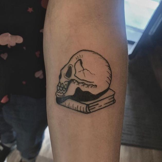 crâne sur le tatouage de livre